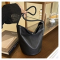 Detailansicht der schwarzen Bucket Bag aus genarbtem Leder mit dekorativer Metallkette - Schwarz