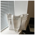 Detailed macro view of white textured fabric and sturdy handle on large tote bag - White