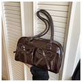 Detail of dark brown leather shoulder bag featuring bow accents and functional pockets - Coffee