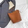 Sac seau minimaliste en cuir marron avec breloque en métal et longue bandoulière - Marron