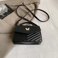 Borsa a tracolla nera in ecopelle trapuntata con elegante fibbia a farfalla bianca - Nero