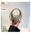 Macro detail of golden quilted handbag with high-shine metallic finish and chain - Yellow