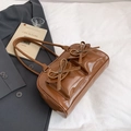 Brown vintage shoulder bag with front pockets and decorative leather bows in glossy finish - Brown