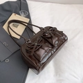 Dark brown shiny leather shoulder bag with bow pockets in a stylish urban outfit setting - Brown