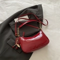 Sac demi-lune rouge verni avec breloque cerise sur une veste de costume grise - Avec Pendentif / Rouge avec pendentif