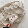 Mini borsa a tracolla bianca con stampa ciliegie e fibbia dorata su un blazer beige - Ciliegia Bianca