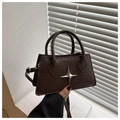 Detailed view of woven texture and silver star metal buckle on dark brown crossbody bag - Dark Brown