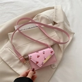 Pink mini crossbody bag with cherry pattern and gold metal buckle on white blazer - Pink Cherry