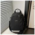 Détail du sac à dos en nylon noir avec logo métallique et finitions soignées de la fermeture - Noir