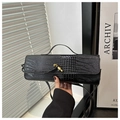 Détail d'un sac à main en cuir noir façon crocodile avec fermoir doré et bandoulière - Noir