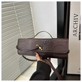 Détail du sac marron foncé effet croco avec fermoir noeud doré et fine bandoulière - café