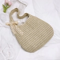 Straw tote bag in beige with delicate white lace bow detail on a fabric background - With Pendant / Off White