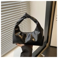 Detalle de un bolso hobo de charol negro con asa anudada y un acabado brillante - Negro