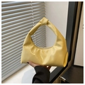 Primer plano del bolso estilo dumpling en charol amarillo brillante con asa de nudo y cremallera - Amarillo