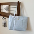 Borsa tote celeste goffrata con fiocco in pizzo in un ambiente minimalista - Senza sciarpa / Blu