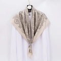 Luxurious beige paisley silk scarf draped over a white shirt with camellia hanger decor - Khaki