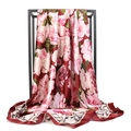 Detail of red floral satin scarf featuring pink flower print on a metal stand - Red
