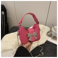 Détail du mini sac rose vif avec ornement nœud argenté et fine bandoulière en chaîne - Rose rouge