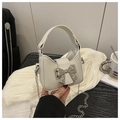Dettaglio della mini borsa bianca in pelle PU con fiocco in metallo argento e catena - Bianco