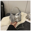 Dettaglio della mini borsa argento con fiocco metallico e tracolla a catena elegante - Argento
