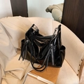 Borsa tote in vernice nera lucida con cerniere argentate su una sedia in tessuto - Con Ciondolo / Nero