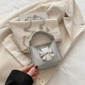 Mini silver bow handbag with metallic chain strap on a blazer background - Silver