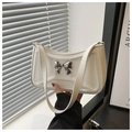 Detail of white leather shoulder bag with quilted geometric pattern and silver bow decor - White