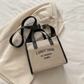 Bolso tote de lona beige con ribete de cuero negro y correa ajustable - Negro