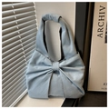 Detailed view of light blue denim tote bag with structural bow design and sturdy texture - Light Blue