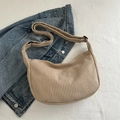 Beige corduroy crossbodytas in halvemaanvorm met verstelbare riem op denim achtergrond - Khaki