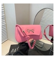 Detailed close-up of pink PU leather bag with golden metal bow and knot strap details - Pink