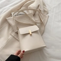 Minimalistische cremeweiße Umhängetasche mit goldener Schnalle auf weißem Sakko - Weiß