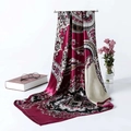Detail view of burgundy paisley satin scarf draped on a metal stand with floral decor - Burgundy Paisley