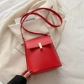 Borsa a tracolla minimalista in pelle rossa con chiusura dorata su abito beige - Rosso