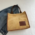 Fashionable yellow corduroy tote bag with brown handles and a leather brand patch - Yellow