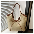 Detailaufnahme der Strohtasche mit braunem Lederbesatz und zarter Schleife - Braun