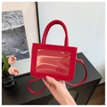 Detail of red PU leather bag featuring a transparent display window and top handle - Red