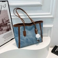 Denim tote bag with brown leather trim and plush charm on a white artistic stand - With Pendant / Blue