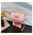 Detalle de mini bolso rosa acolchado con cierre giratorio dorado y acabado brillante - Rosa