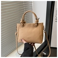 Nahaufnahme hellbraune Eimer-Tasche aus Leder mit Litschi-Muster und Goldbeschriftung - Khaki