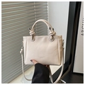 Detailansicht der beigen Bucket Bag mit Litschi-Textur, Knotengriffen und Silberbeschlag - Gebrochenes Weiß