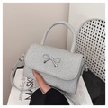 Dettaglio della borsa mini con paillettes argento, fiocco in metallo e tracolla - Argento