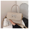 Dettaglio della mini borsa glitter champagne con fiocco in metallo e manico superiore - Oro
