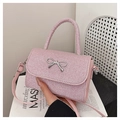 Dettaglio della trama glitter rosa e fibbia a fiocco in metallo argentato di questa borsa - Rosa