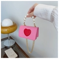 Detailed shot of pink heart crossbody bag with pearl handle and gold chain strap - Pink