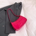 Glossy bright pink patent leather baguette bag with gold hardware on a gray background - Rose Red