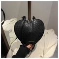 Detailed view of black heart-shaped handbag with woven texture and gold fashion lettering - Black
