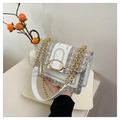 Détail du sac bandoulière en tweed avec boucle dorée et chaîne sur plateau décoratif - Blanc