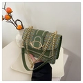 Détail d'un sac bandoulière en tweed vert avec bordure en cuir et boucle dorée - Vert