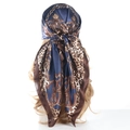 Blue leopard and chain print satin silk scarf styled as a headwrap on a model - Navy Blue